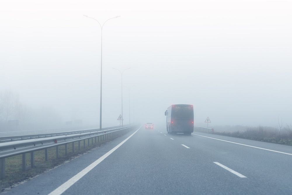 Autokar na autostradzie w Niemczech o poranku, lekka mgła nad polami